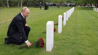 بوتين راكعًا ويضع باقة من الزهور